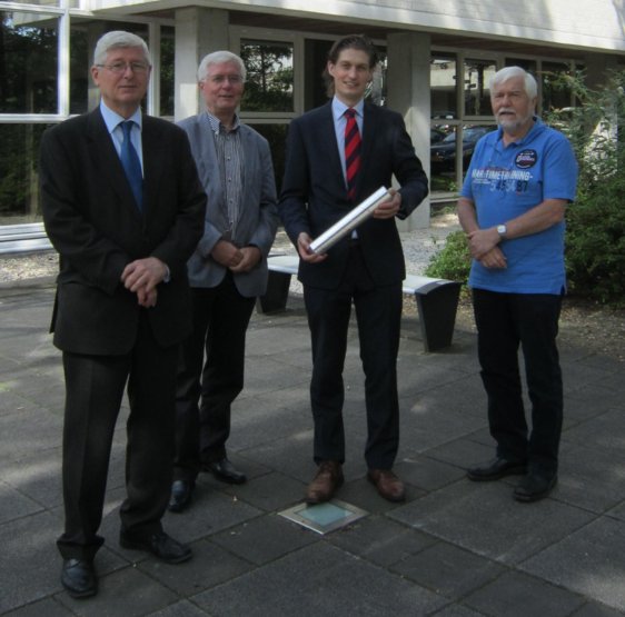 Lucien voor de aula omringd door familie